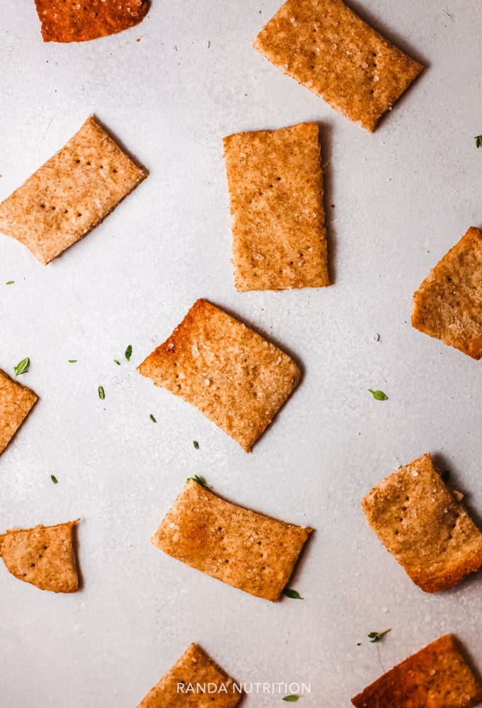 baked gluten free crackers on a counter with herbs