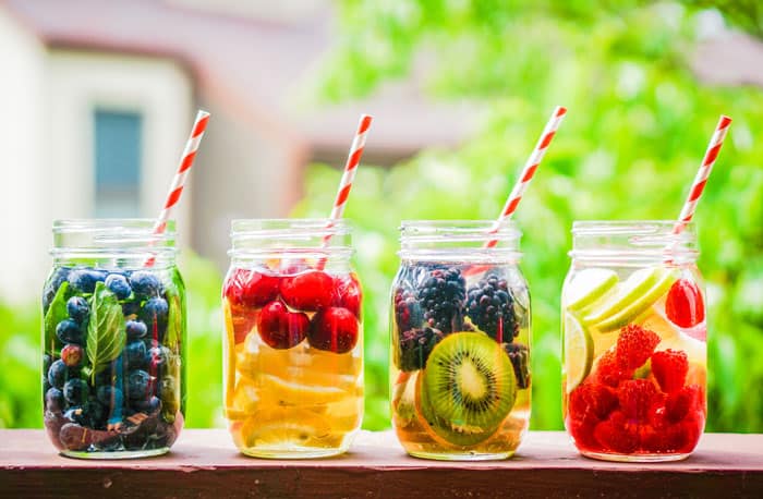 Mason jars of water with fruit in it