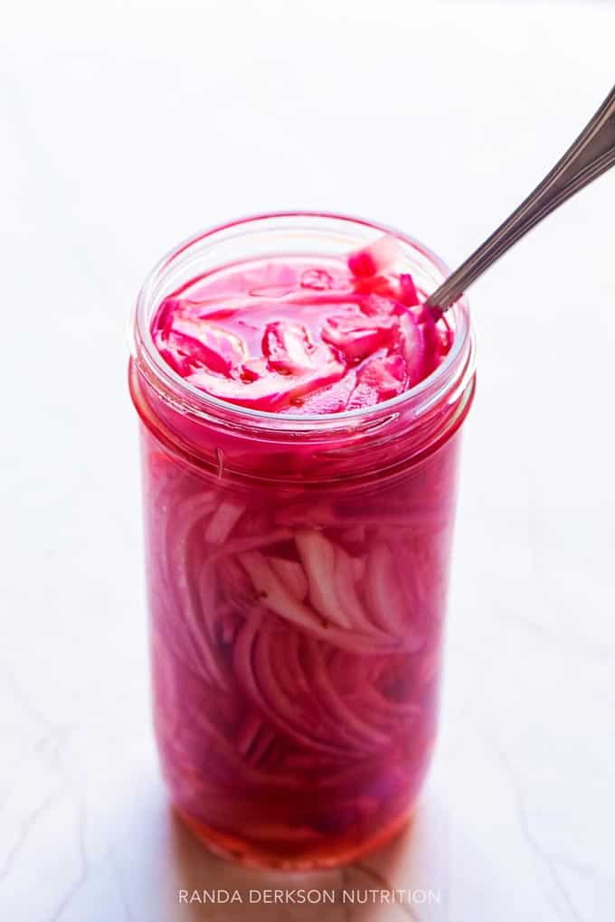 homemade pickled onions in a tall glass mason jar