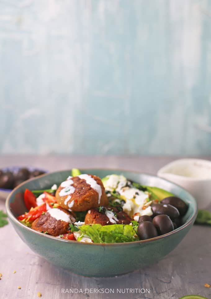 plant based salad in a blue bowl with a greek yogurt tahini dressing