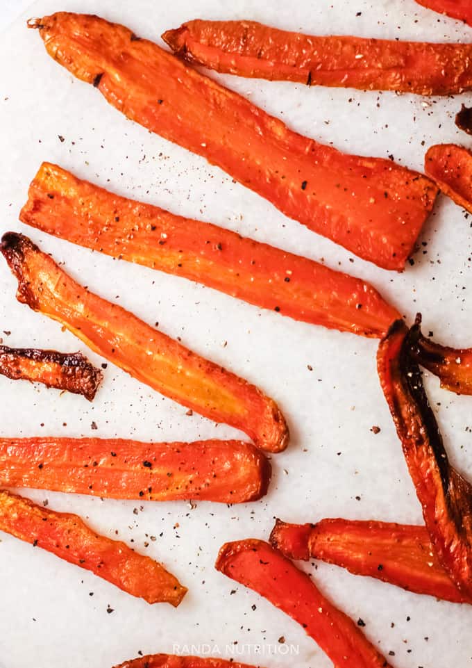 baked carrot fries on a white background