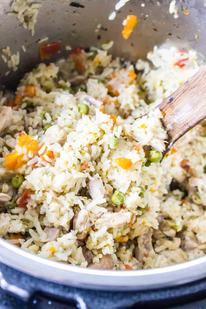 mexican chicken and rice being stirred in with frozen vegetables in the instant pot