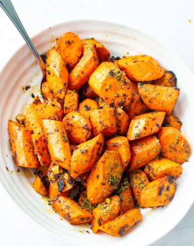 overhead view of crunch oven roasted carrots with a serving spoon as a side dish