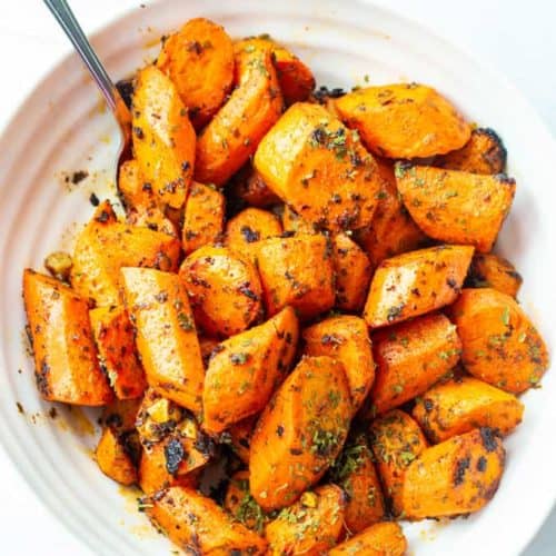 overhead view of crunch oven roasted carrots with a serving spoon as a side dish