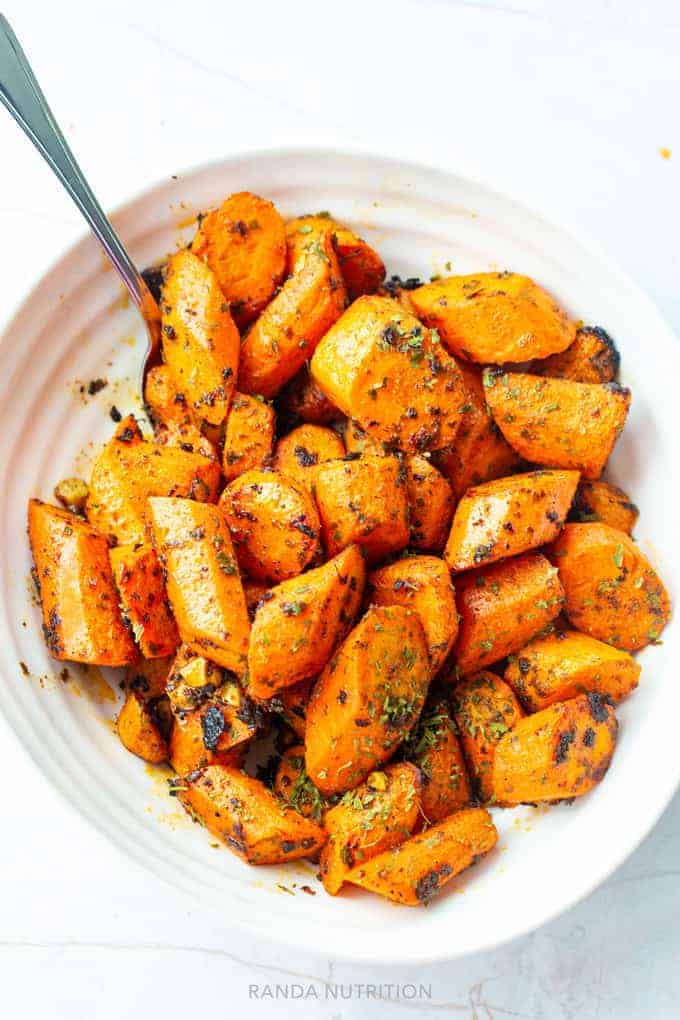 overhead view of crunch oven roasted carrots with a serving spoon as a side dish