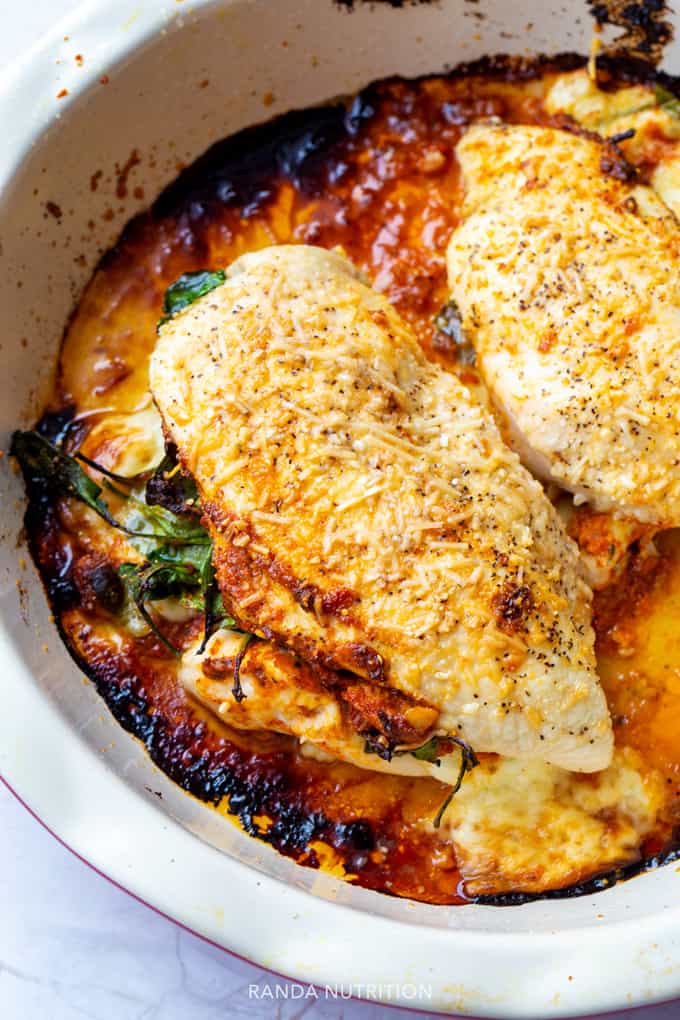 closeup of these Romesco Stuffed Chicken Breasts in a white casserole dish