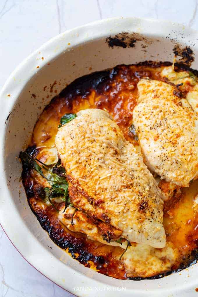 closeup of these Romesco Stuffed Chicken Breasts in a white casserole dish