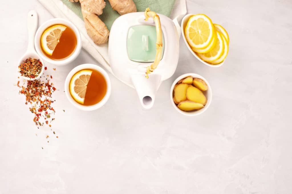 tea pot with tea with lemon, honey, and ginger