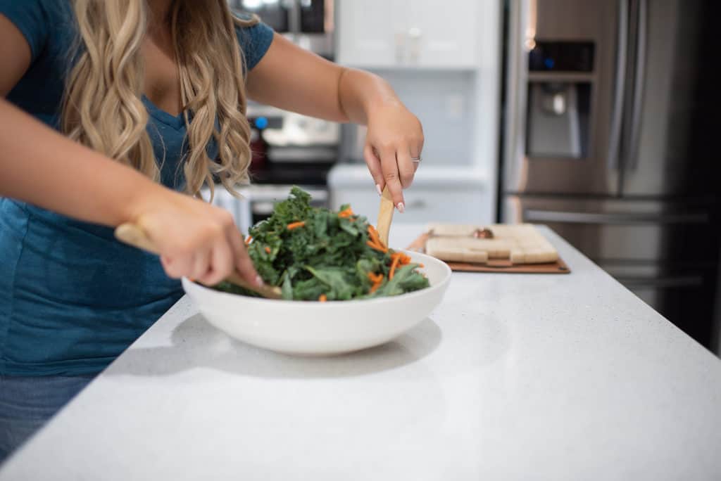 tossing kale salad