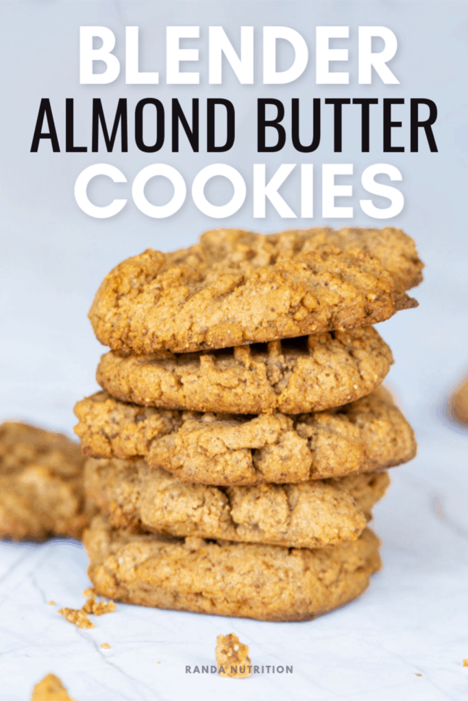 almond butter cookies stacked on top of one another with crumbs