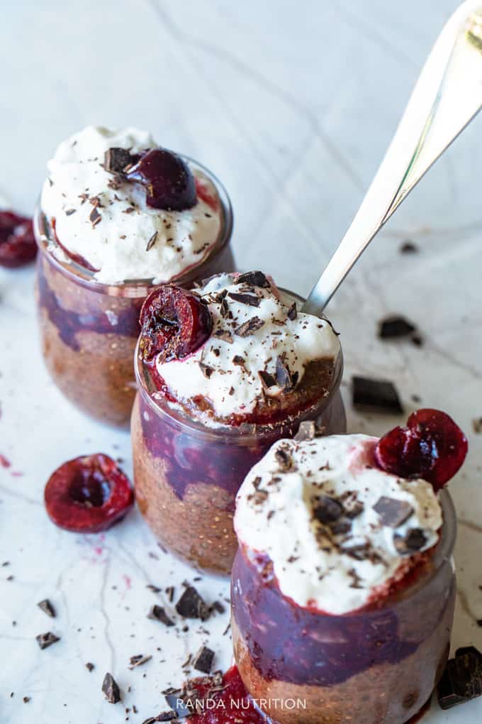 cherry chia pudding topped with shaved chocolate and coconut whipped topping
