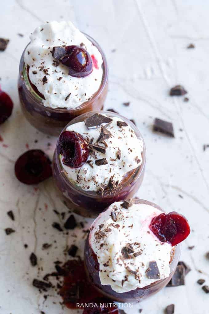 cherry chocolate chia pudding topped with coconut whip cream and chocolate flakes