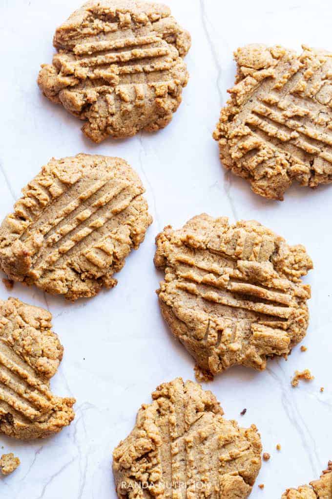 freshly baked almond butter cookies on a marble slab with crumbs