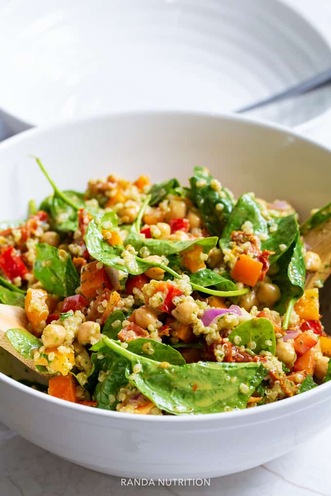 spinach quinoa salad in a white salad bowl