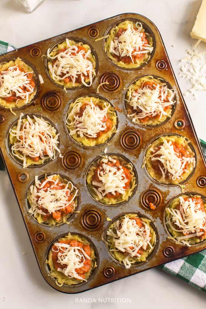 squash, spaghetti sauce, and cheese ready to bake in a muffin tin