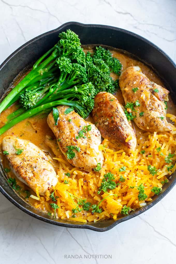 cooked chicken breasts in a coconut red curry sauce with broccolini and butternut squash noodles.