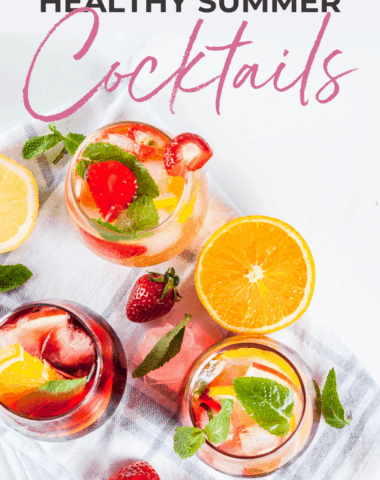 healthy summer cocktails on a white marble background and topped with fruit and mint leaves