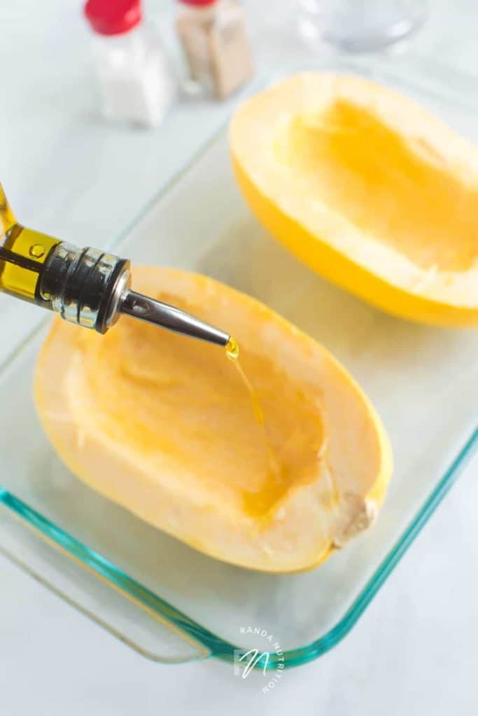 spaghetti squash being drizzled with olive oil