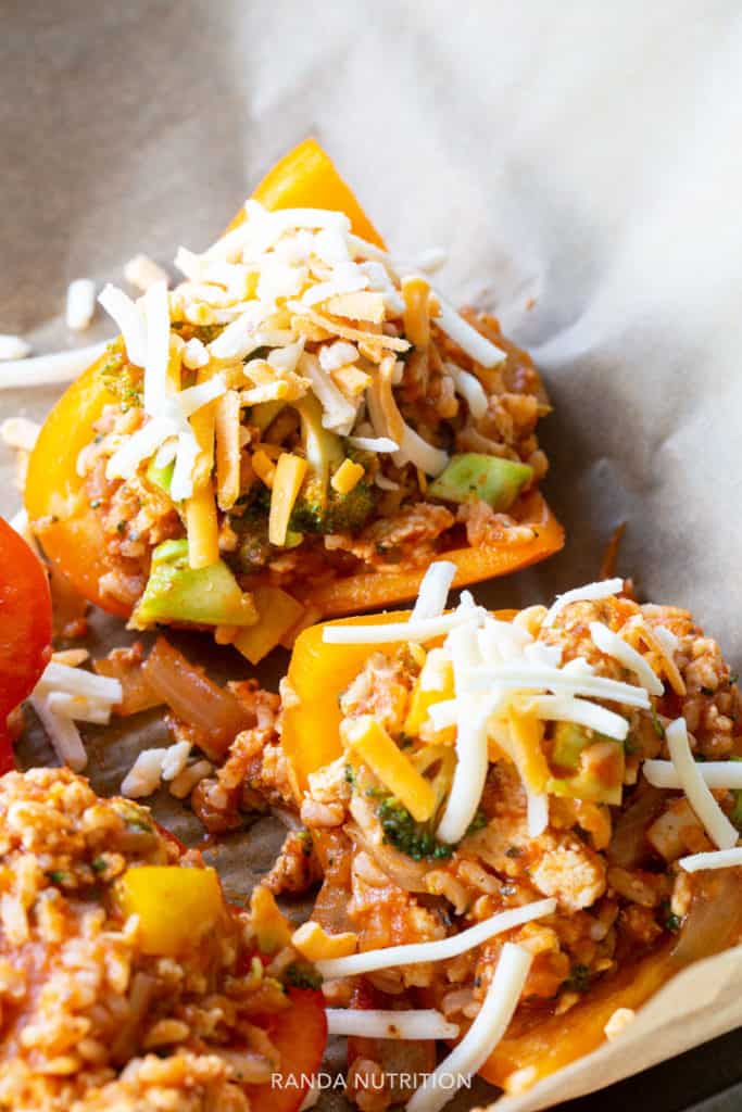 Stuffed peppers ready to go in the oven topped with shredded cheese