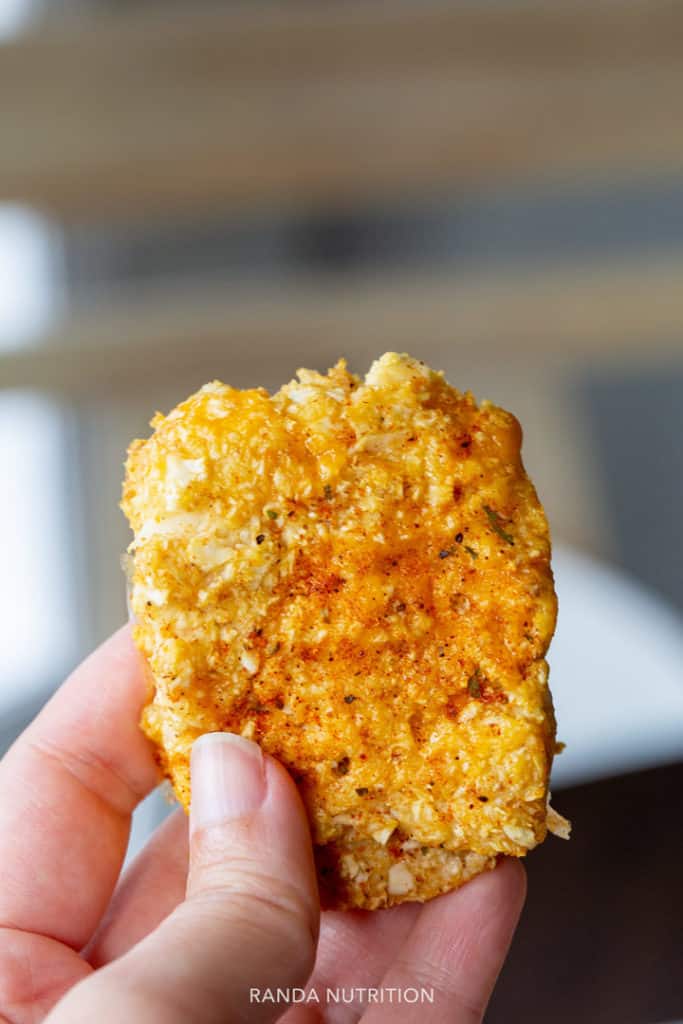 a hand holding up one of these  cauliflower hashbrown patties