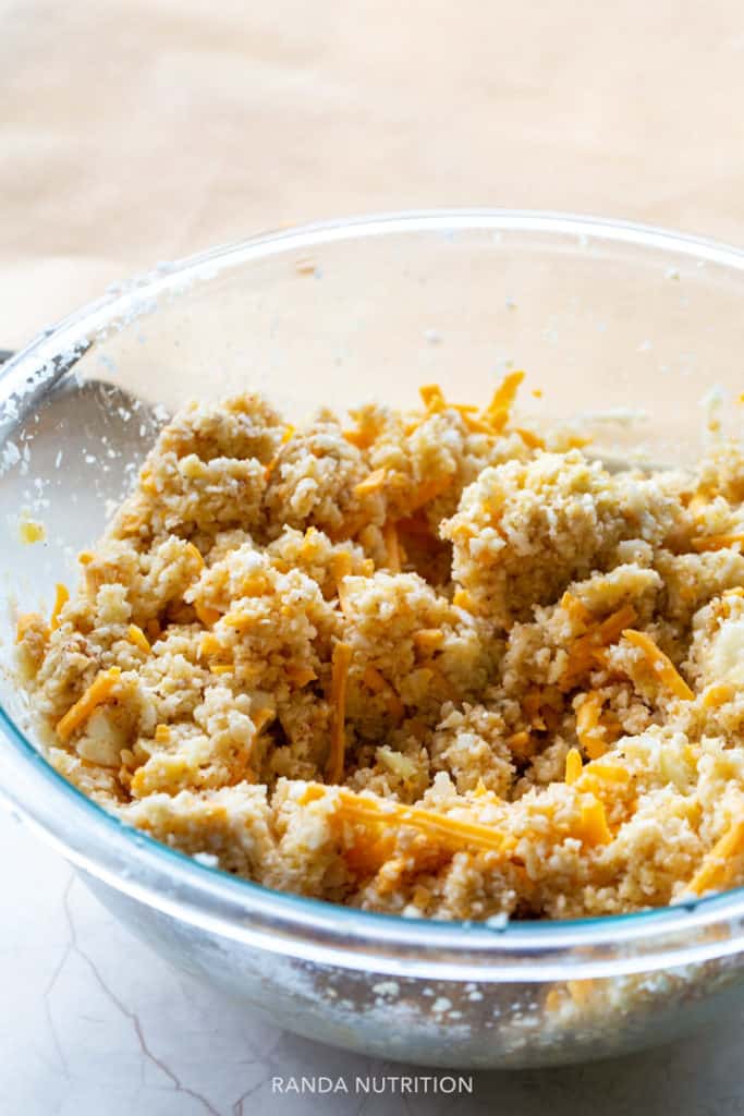 cauliflower rice mix with cheese in spices in a glass bowl