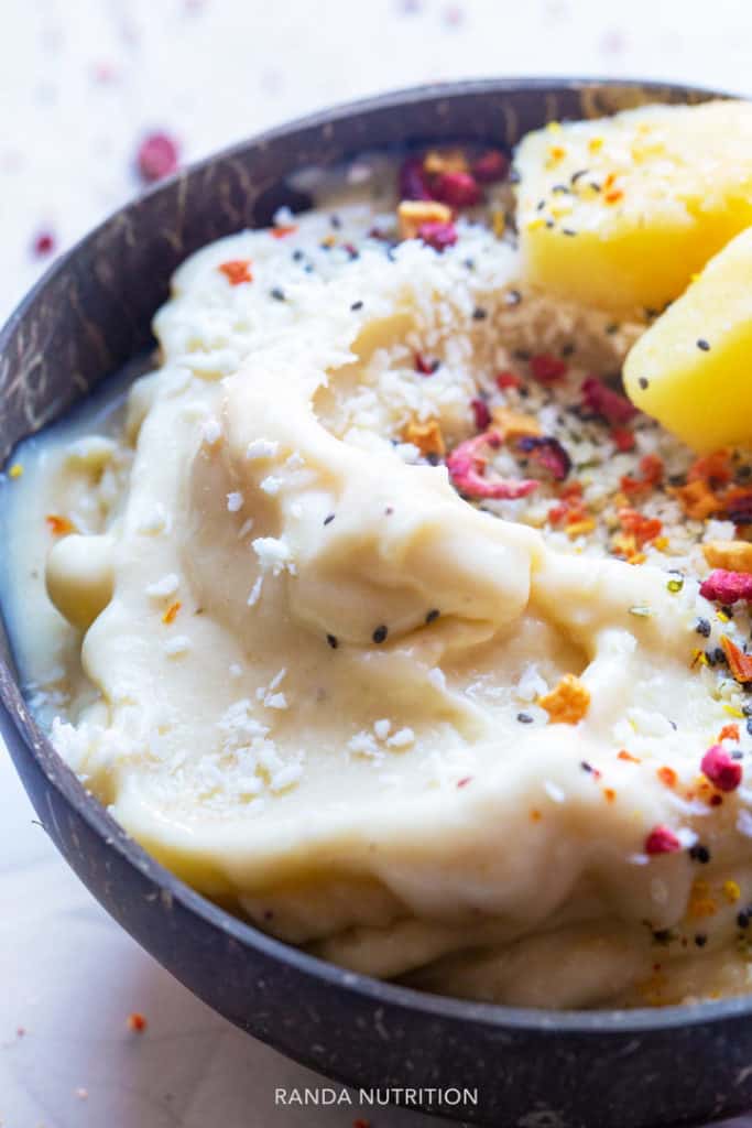 Coconut pineapple frozen yogurt in a coconut shell bowl