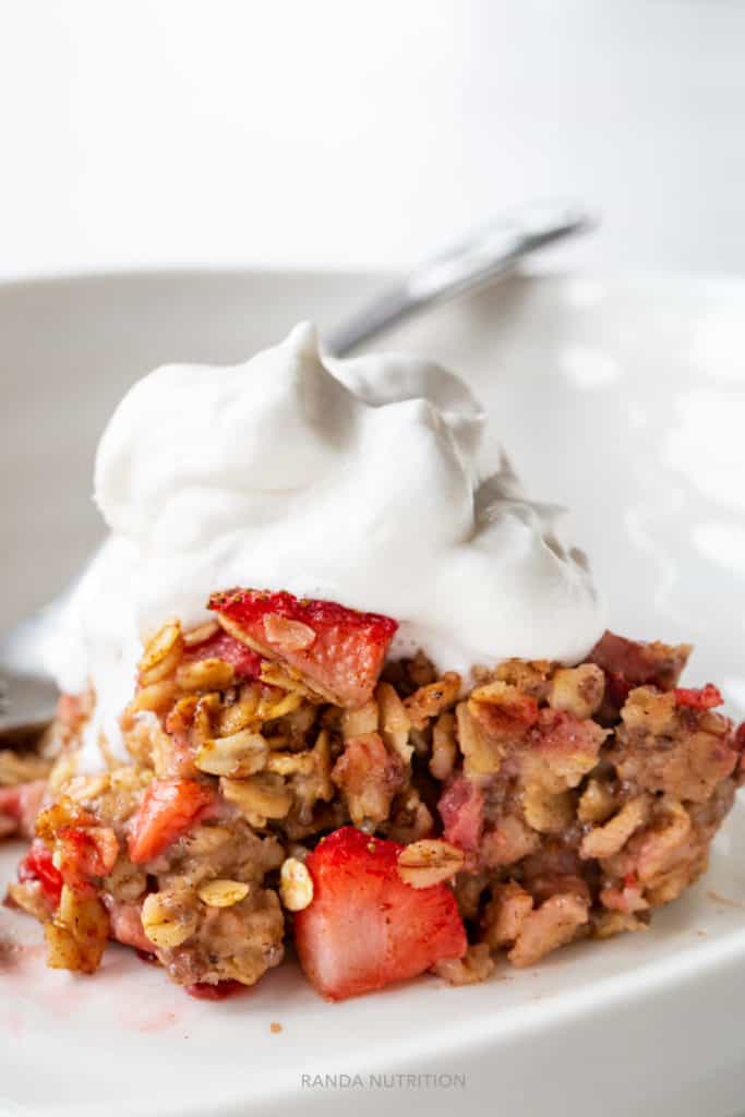 healthy baked oatmeal topped with fruit and coco whip