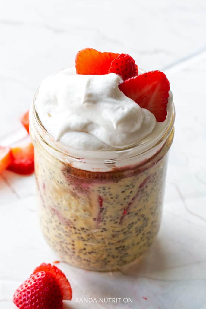 overnight oats with whipped cream and strawberry rhubarb sauce for a healthy breakfast