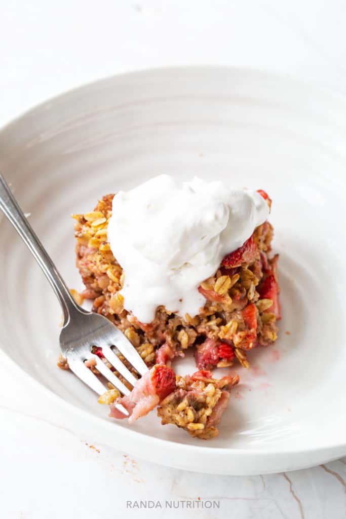 sliced of baked oatmeal stopped with coconut whipped cream