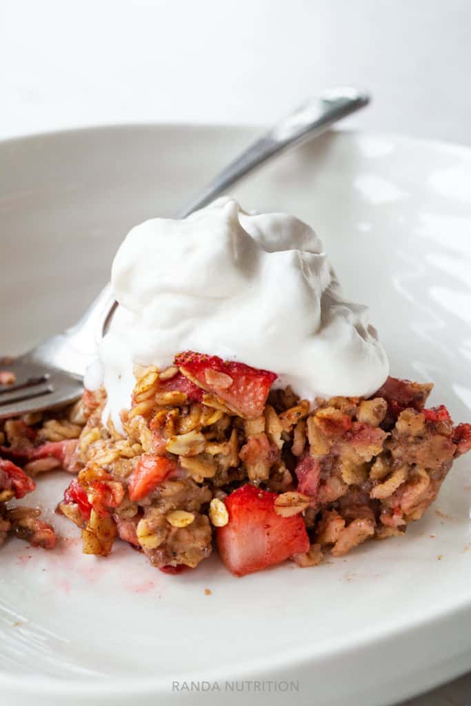 sliced strawberry rhubarb baked oatmeal topped with So Delicious CocoWhip