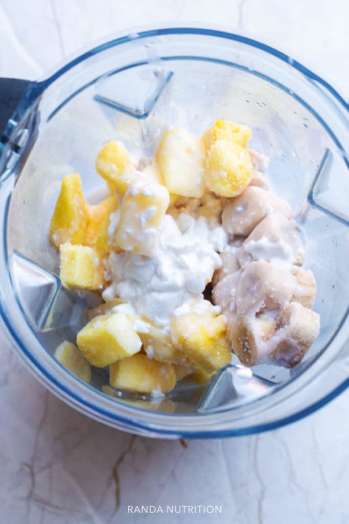 Frozen pineapple, bananas, and coconut milk in a Vitamix