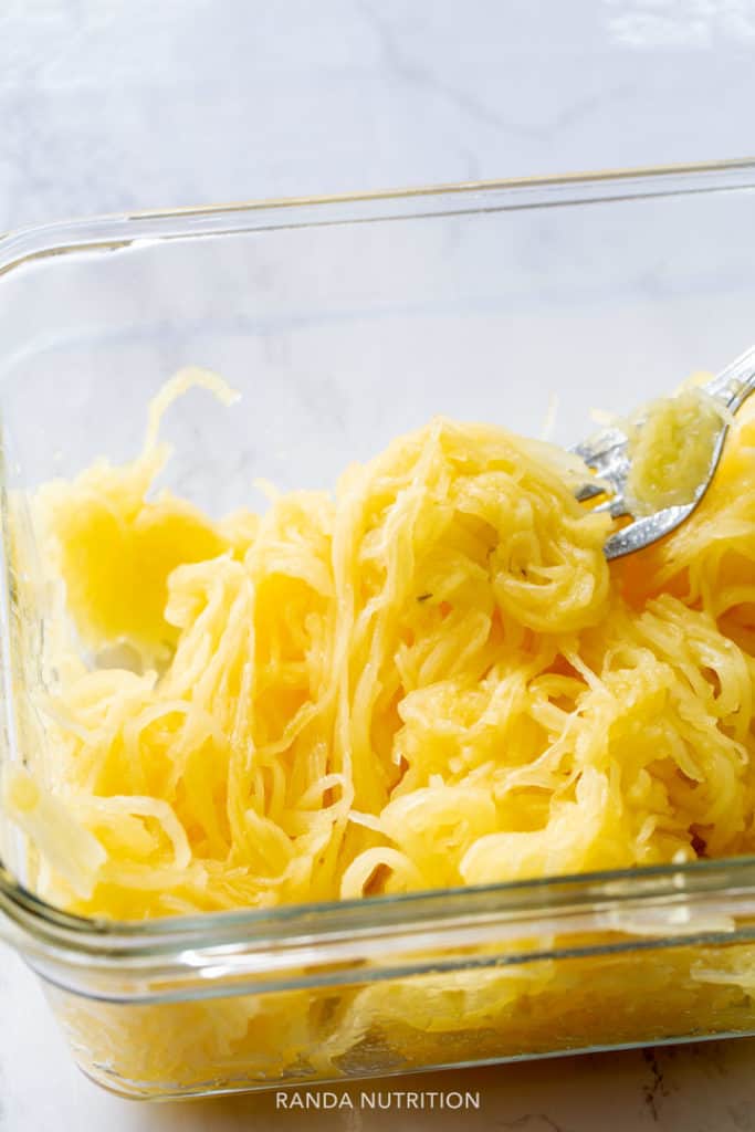 cooked spaghetti squash stands in a glass meal prep container