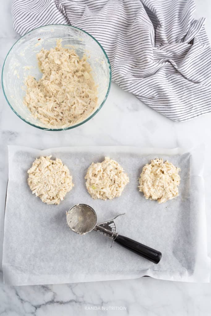 using an ice cream scoop to scoop crab mix to form patties