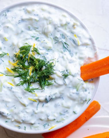 overhead look at a greek yogurt dip with lemon zest, dill, and cucumber