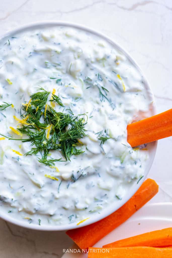 overhead look at a greek yogurt dip with lemon zest, dill, and cucumber