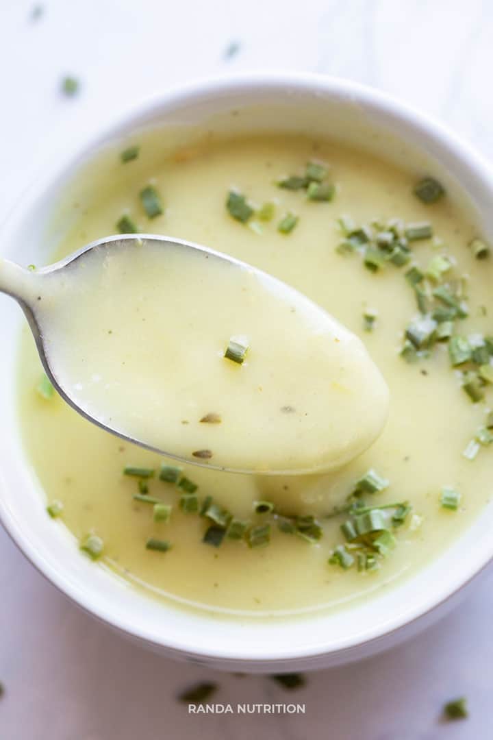 thick and creamy potato leek soup being lifted up by a spoon