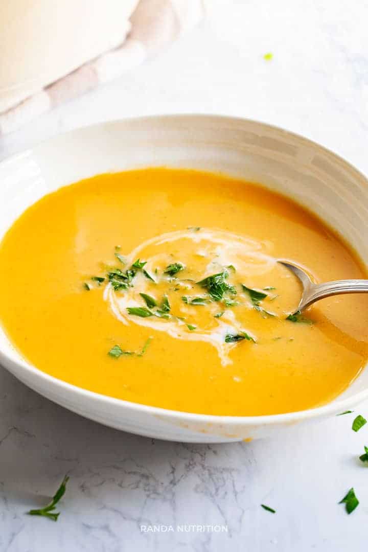 curried potato leek soup in a bowl with a spoon topped with parsley