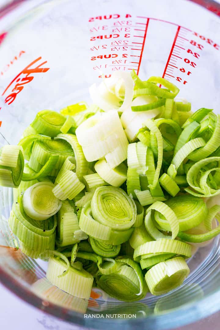 a glass pyrex measuring cup with 2 cups of sliced leeks inside