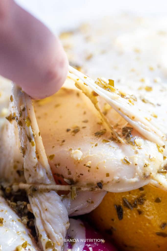 separating the skin from the chicken to add flavor to the breast