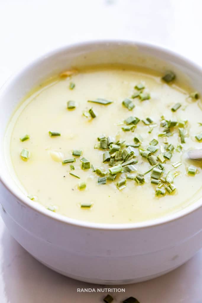 dairy free potato leek soup recipe in a white bowl garnished with chopped chives