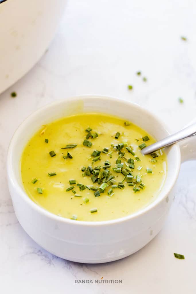 dairy free potato leek soup recipe in a white bowl garnished with chopped chives