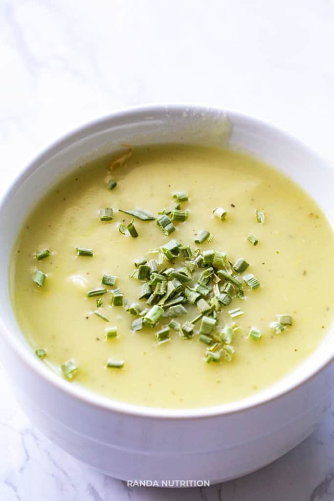 dairy free potato leek soup recipe in a white bowl garnished with chopped chives