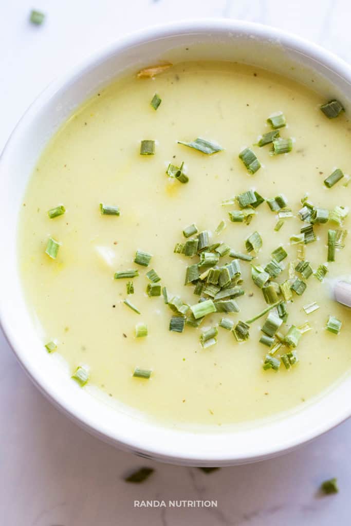 dairy free potato leek soup recipe in a white bowl garnished with chopped chives