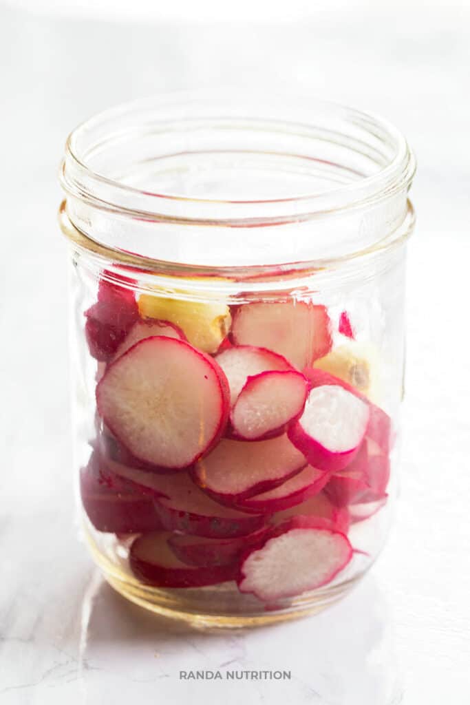 radishes in a clean mason jar with garlic