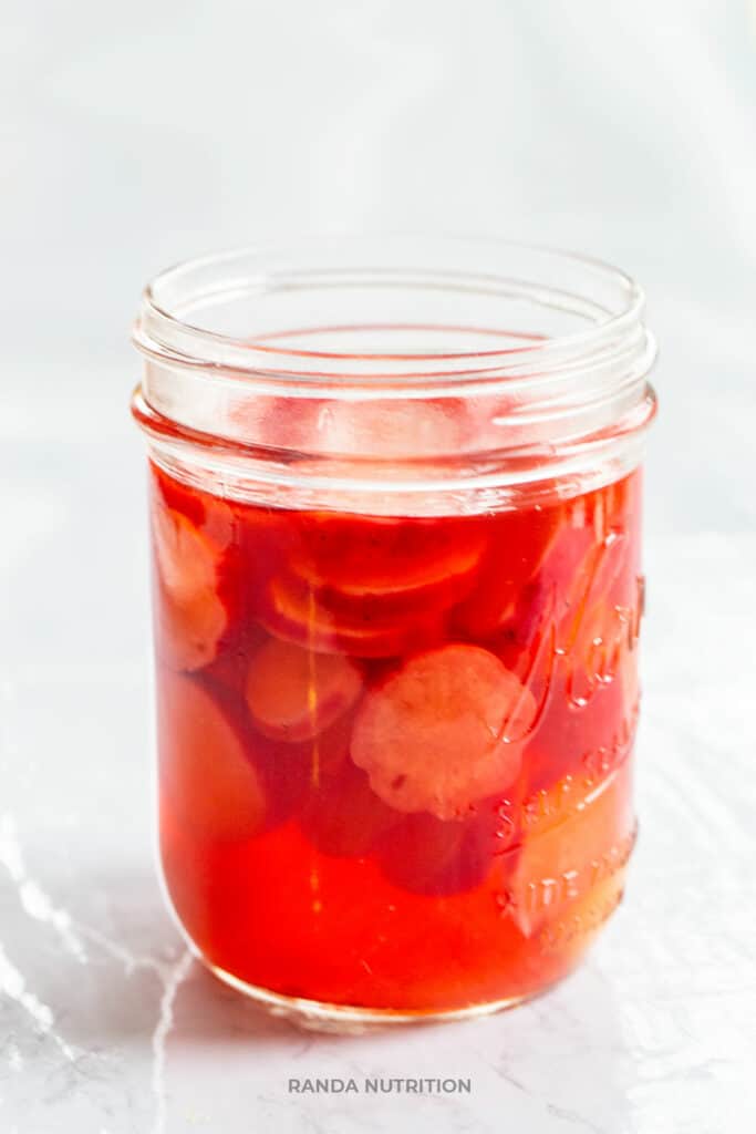 pickled radishes in a mason jar with apple cider vinegar