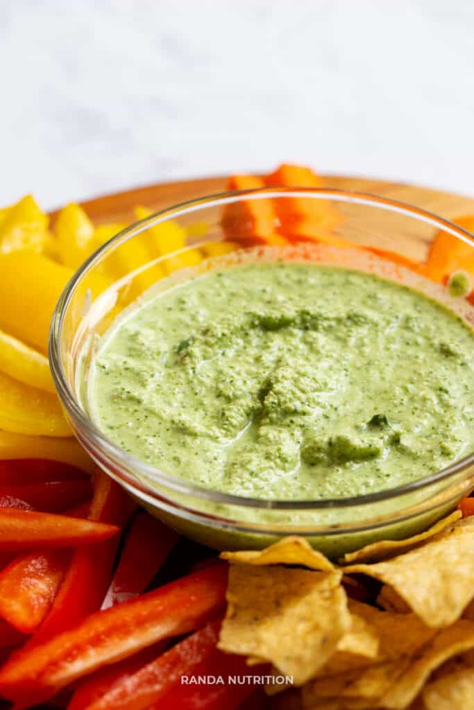 plate of tortilla chips, vegetables and healthy dipping sauce ready for a party