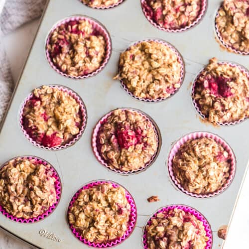 fresh baked raspberry protein oatmeal muffins in a tin with pink silicone liners