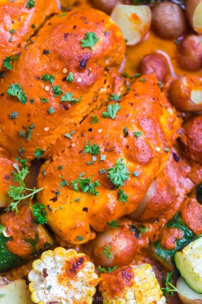 close up of baked chicken with a red pepper sauce on top