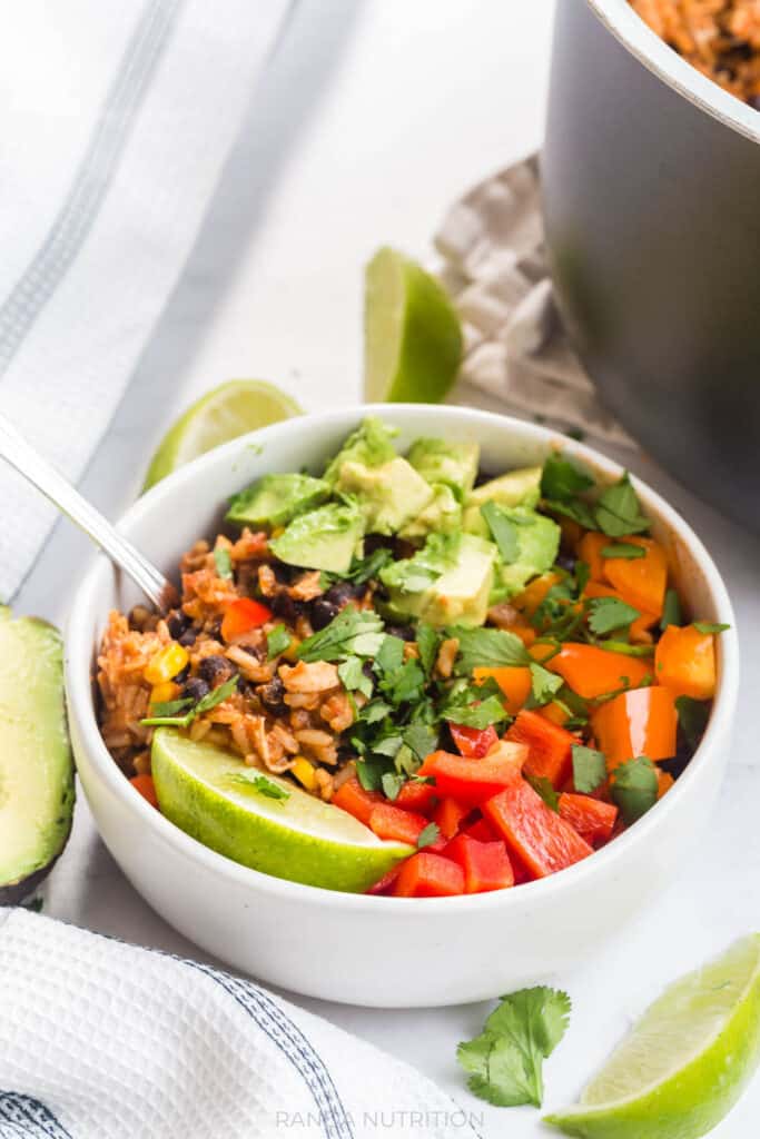 Chicken burrito bowls made in a Ninja Foodi, topped with cilantro, avocado, and raw bell peppers