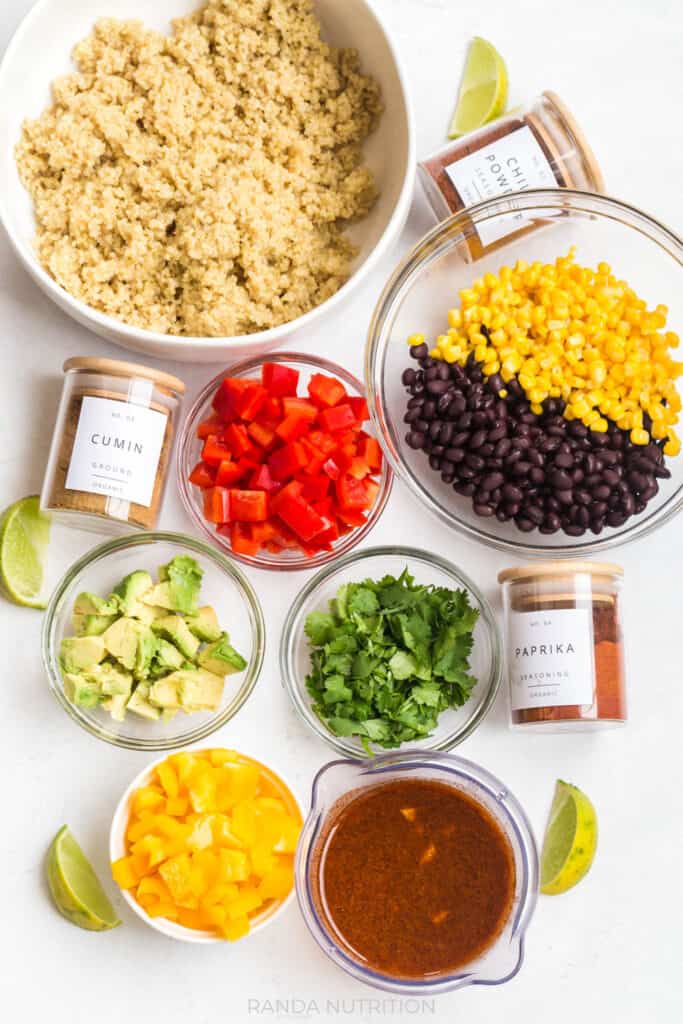 ingredients for mexican quinoa salad laid out with pretty spice jar labels